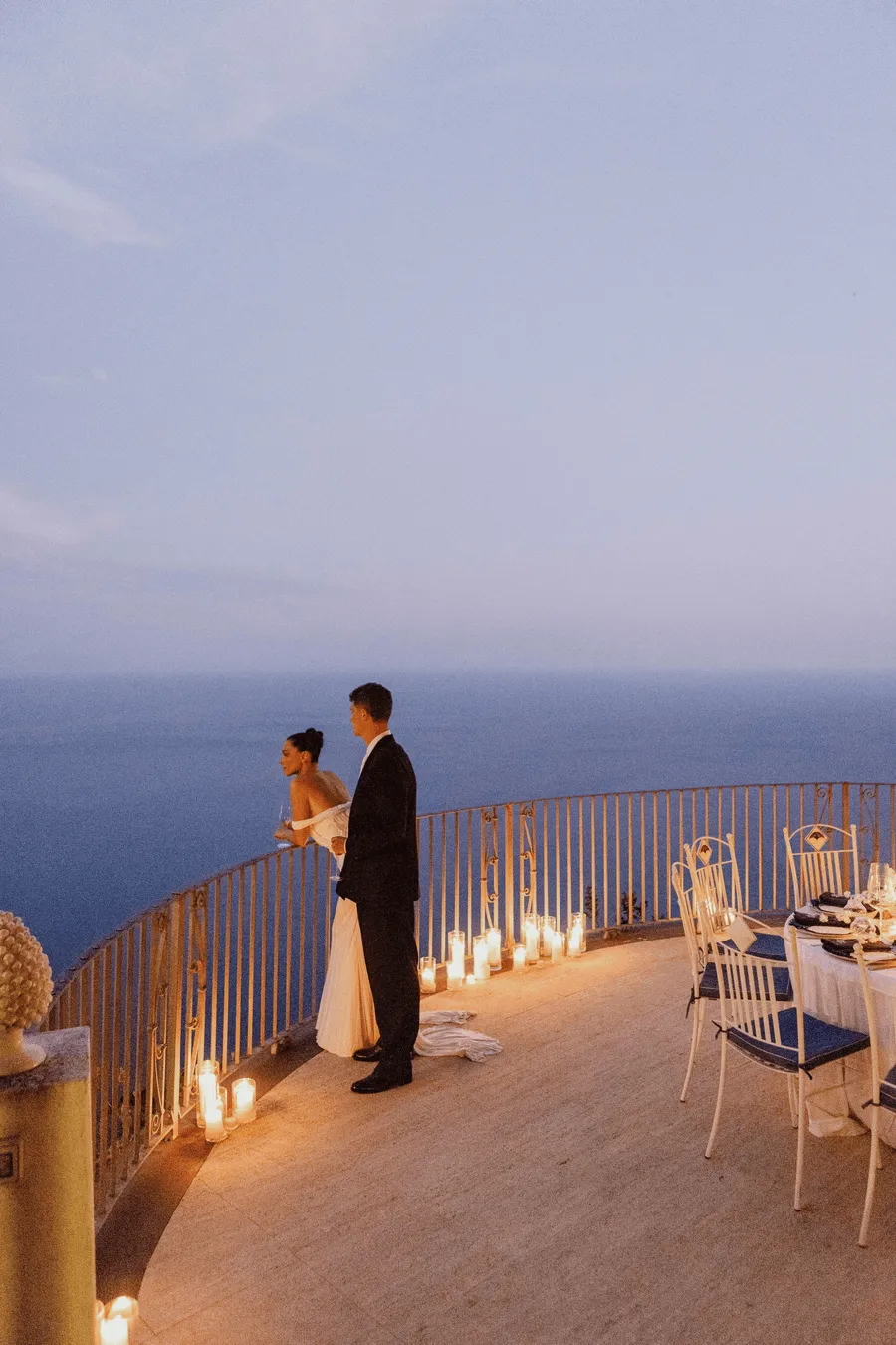 Sposi su una terrazza sul mare illuminata dalle candele